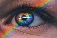 Regenbogen spiegelt sich im Auge einer Frau